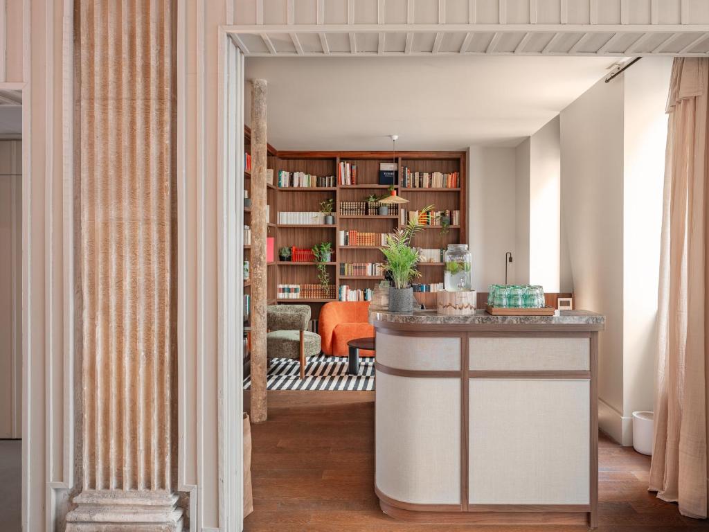 a hallway leading into a living room with a table at Hotel Belleval in Paris