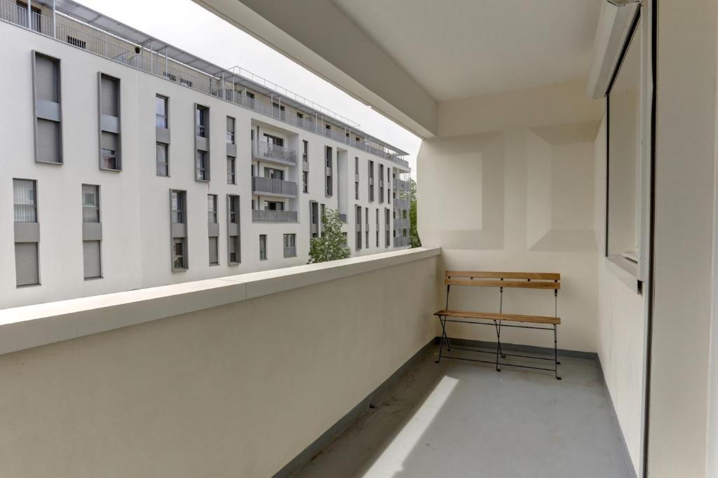 - un balcon avec un banc et un bâtiment dans l'établissement La Marguerite - Guyancourt, à Guyancourt