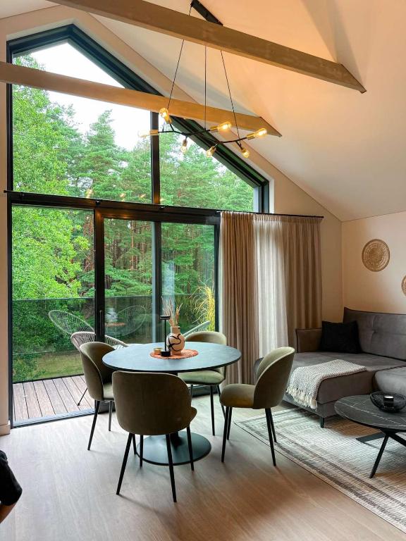 a living room with a table and chairs and a couch at LEX apartments in Palanga