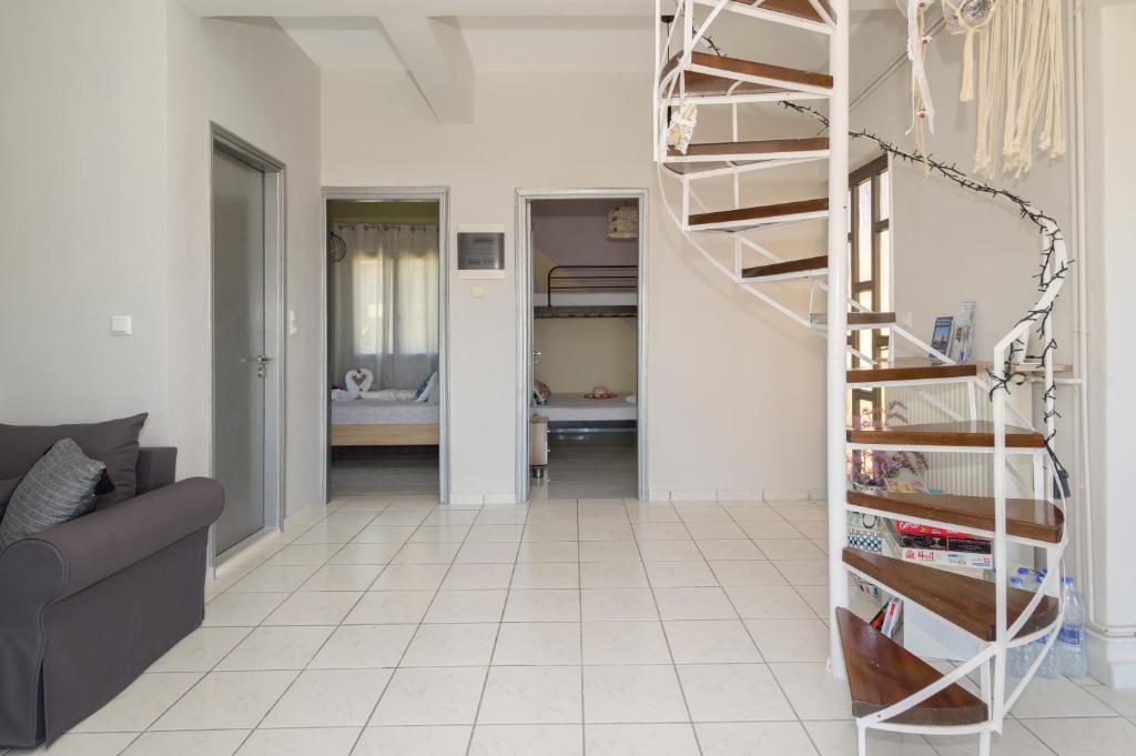 a spiral staircase in a living room with a couch at Golden Navarino's Sunset in Pylos