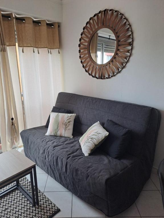 - un canapé noir dans le salon avec un miroir dans l'établissement Studio Port - 2 pers, au Cap d'Agde