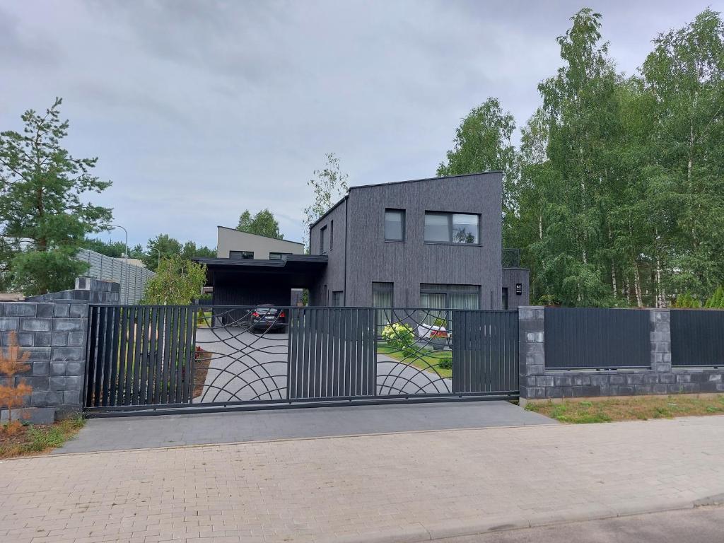a house with a black gate in front of a driveway at Big Mama Koala in Druskininkai