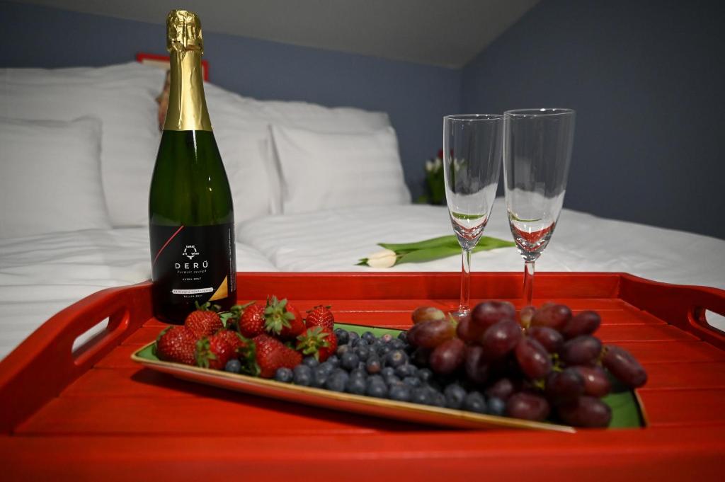 ein Tablett mit einer Flasche Champagner und ein Tablett mit Obst in der Unterkunft Bohém Borklub in Tállya