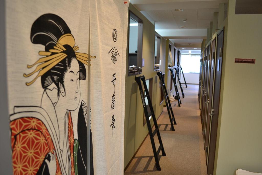 a hallway with a painting of a woman on a wall at 1 Night 1980 Hostel Tokyo Asakusa Simple Stay in Tokyo