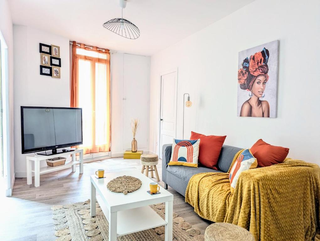 un salon avec un canapé et une télévision dans l'établissement L'escapade des poètes - central - baby-foot, à Béziers