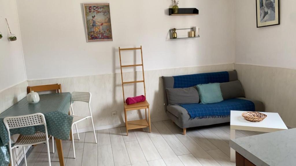 un salon avec un canapé et une table dans l'établissement Deux pièces vintage, à Trouville-sur-Mer