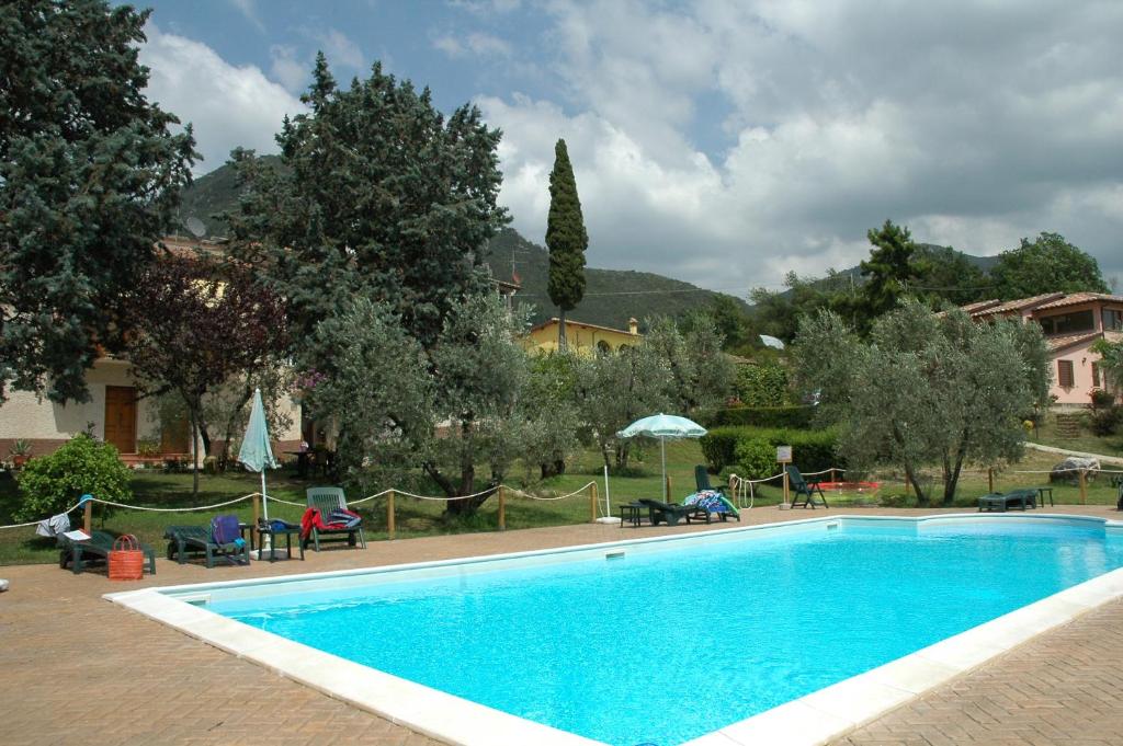 una piscina in un resort con sedie e ombrelloni di Agriturismo La Pila a Ferentillo