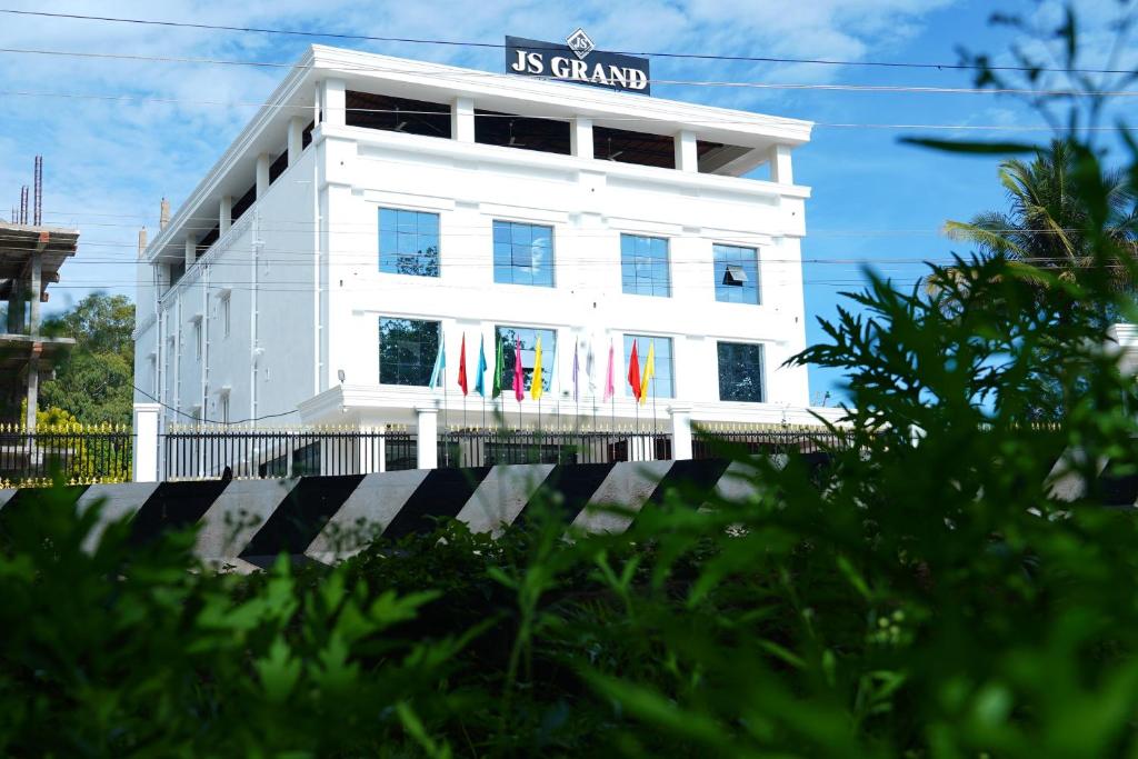 a white building with a sign on it at J S Grand in Yelagiri