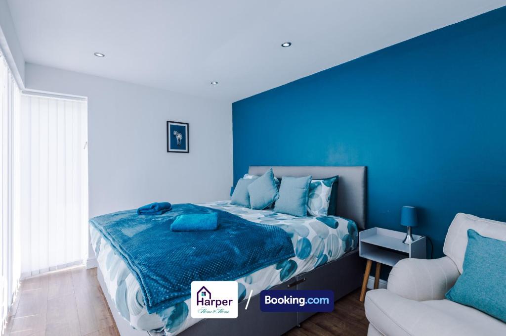 a blue bedroom with a bed and a couch at Modern 4-BR Home Sleeps 10 Ideal for Families Contractors & Groups in Buckley