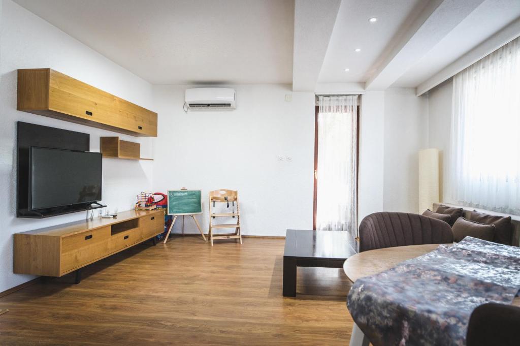 a living room with a television and a couch at Nice Apartment in Gevgelija