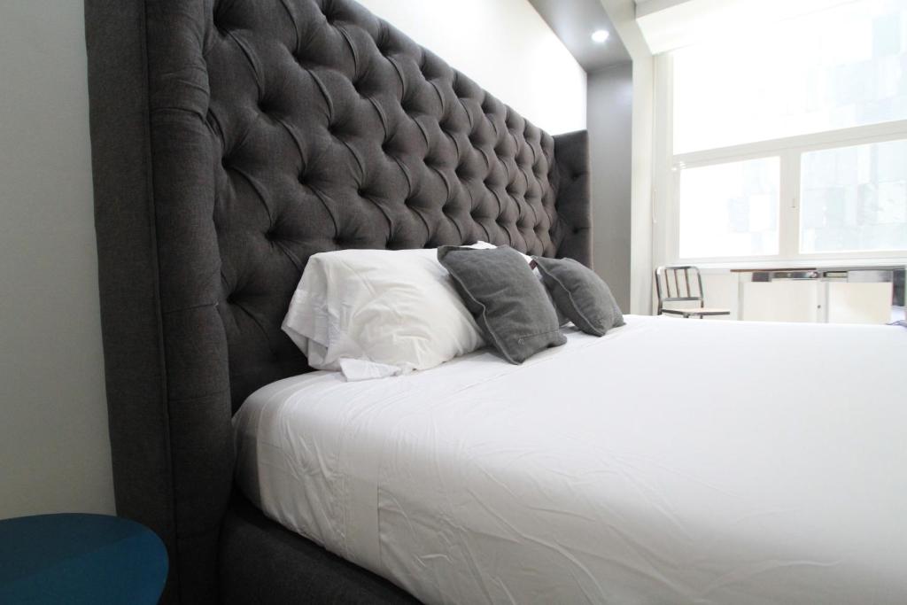 a bedroom with a large bed with a large padded headboard at Boutique Apartment Centro Histórico-402 in Mexico City