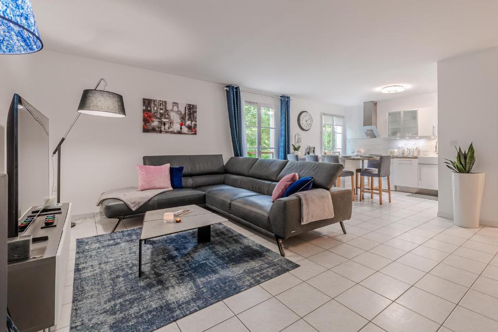 un salon avec un canapé et une table dans l'établissement CM - Le cocon des Champs à 10 min de Disneyland Paris, à Serris