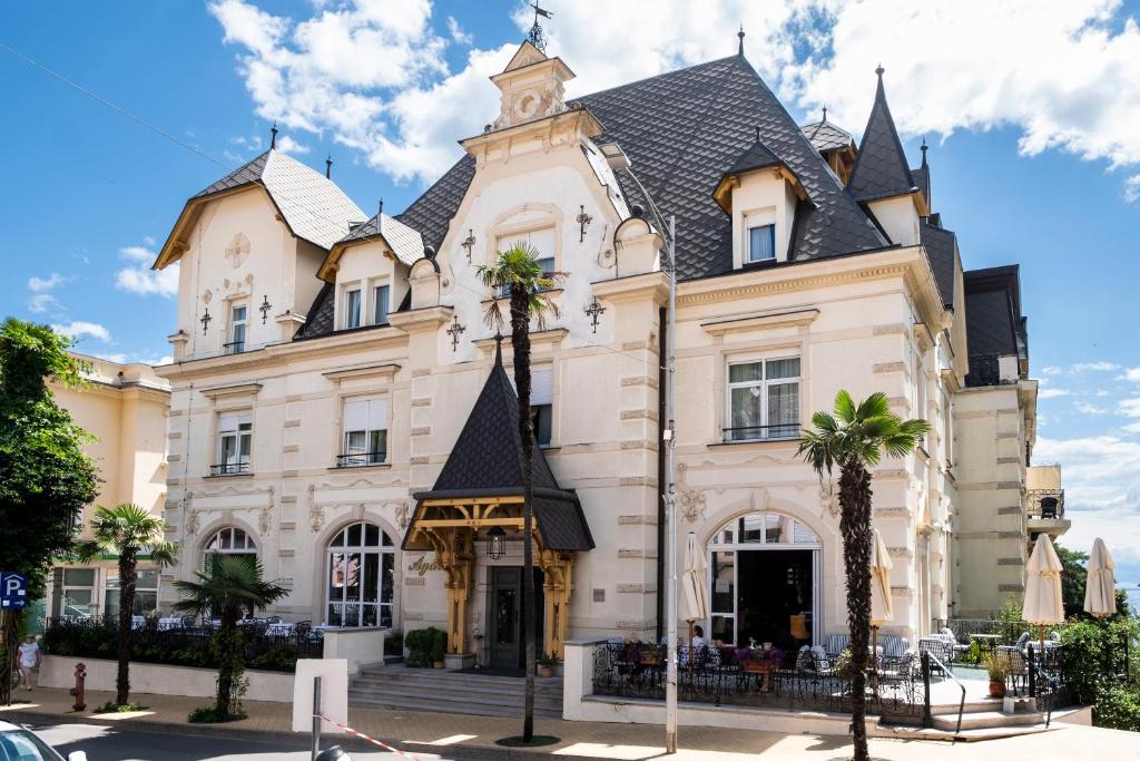 a large white building with a black roof at Amadria Park Hotel Agava in Opatija