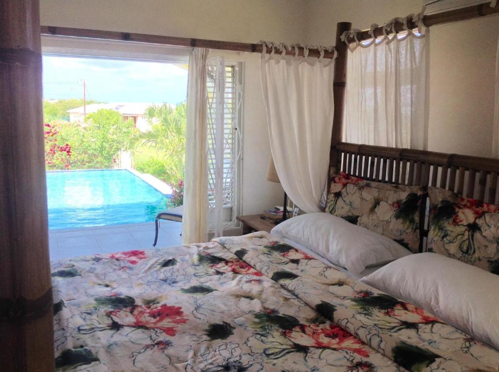 Un dormitorio con una cama y vistas a una piscina. en Remarkable 3-Bed Villa in christ church, en Christ Church