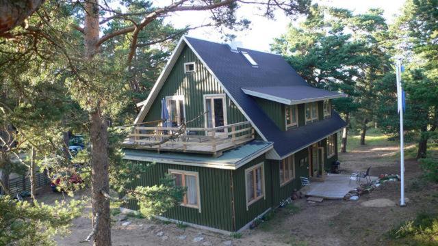 una casa verde con techo azul en el bosque en Samblatalu Homestay, en Laulasmaa