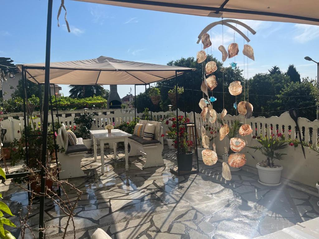 a patio with a table and an umbrella at Стаи за гости Бела in Ahtopol