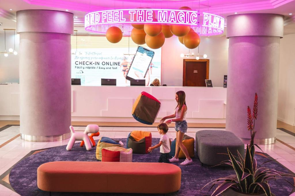 eine Frau und zwei Kinder in einem Zimmer mit Möbeln in der Unterkunft Hotel Magic Games 4 in Oropesa del Mar