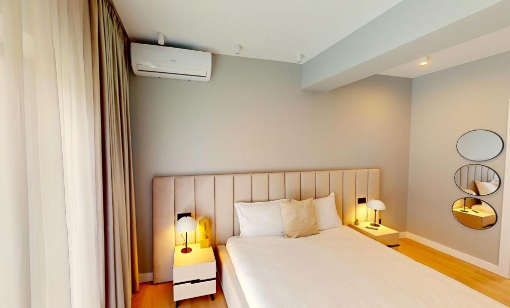 a bedroom with a white bed with two lamps at Casa de vacanta Cris 2 in Băile Olăneşti