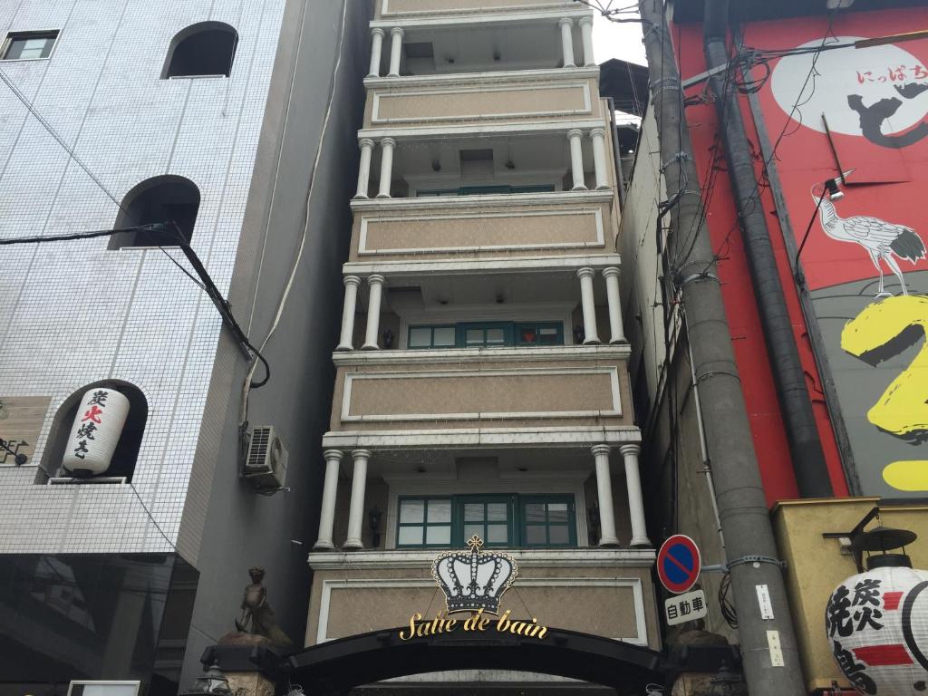 wysoki budynek z znakiem na boku w obiekcie Hotel Salle de bain (Adult Only) w Osace
