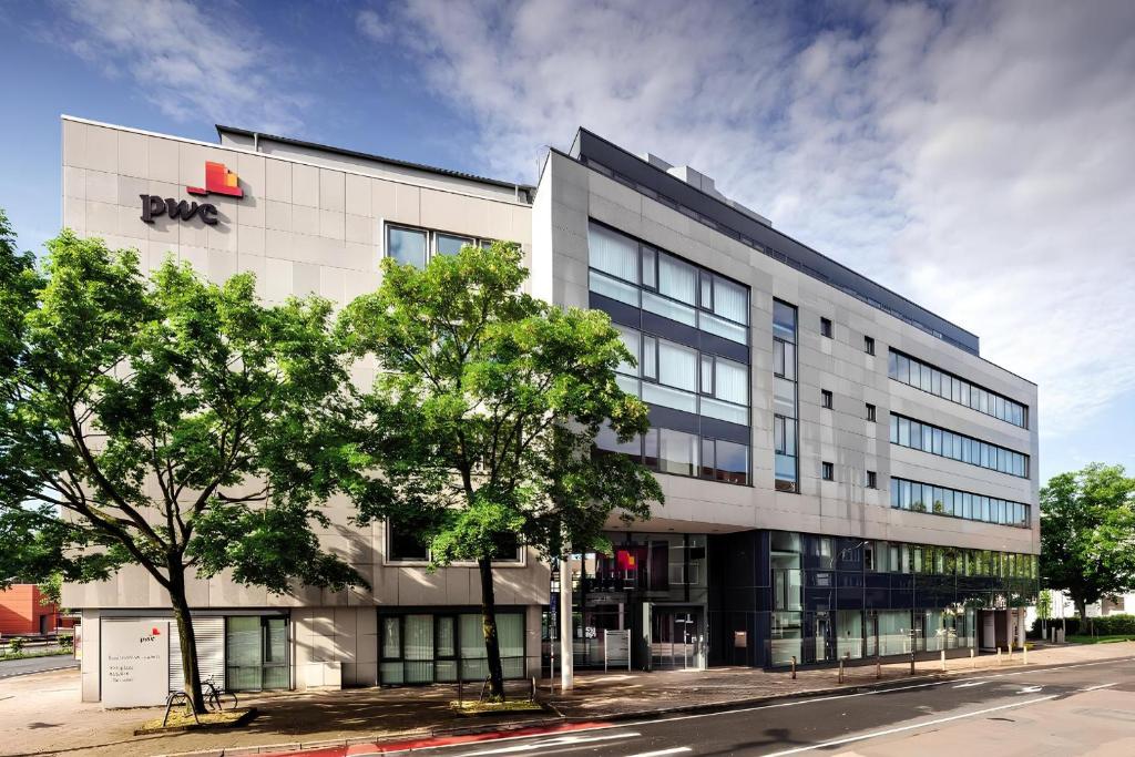 an office building on a street with a tree at Zentrale Wohlfühloase mit Parkplatz in Osnabrück