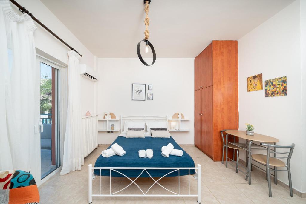 a bedroom with a bed and a table and chairs at A&D Apartments in Porto Rafti