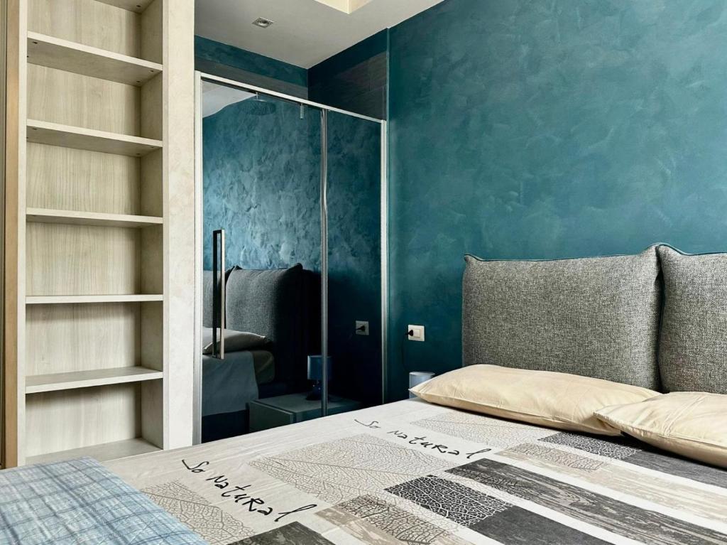 a bedroom with a bed and a blue wall at CASA MILA White in Marina di Cerveteri