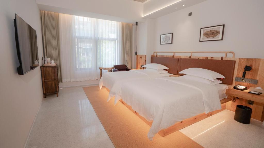 Postel nebo postele na pokoji v ubytování Patio Spring Holiday Inn -- Free round trip pick-up service --Panoramic view of Tianmen Mount
