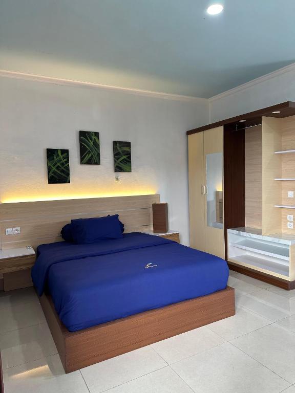 a bedroom with a large blue bed in it at Hotel Any Lestari in Huu