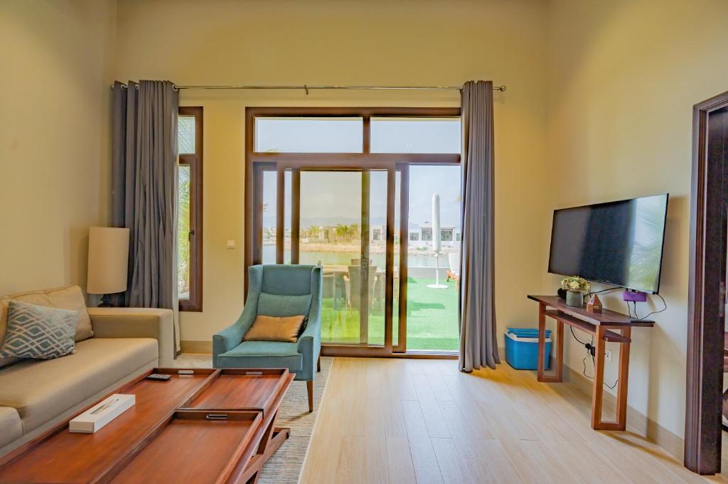 a living room with a couch and a tv at Luxury Hawana Villa in Salalah