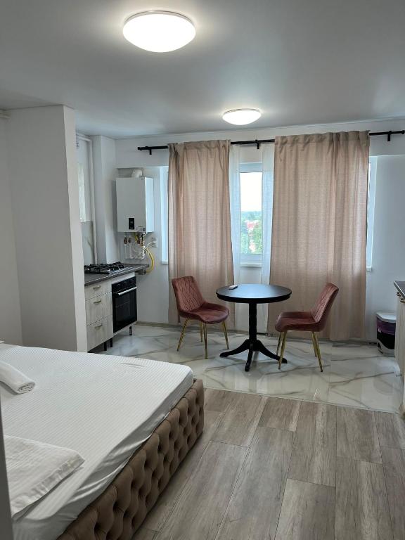 a bedroom with a bed and a table and chairs at Pollux Residence Militari ap 113 in Dudu