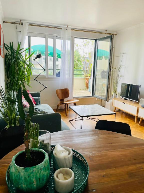 - un salon avec une table et une plante dans l'établissement 2 BEDROOMS & TERRACE with BBQ COURBEVOIE PARIS, à Courbevoie