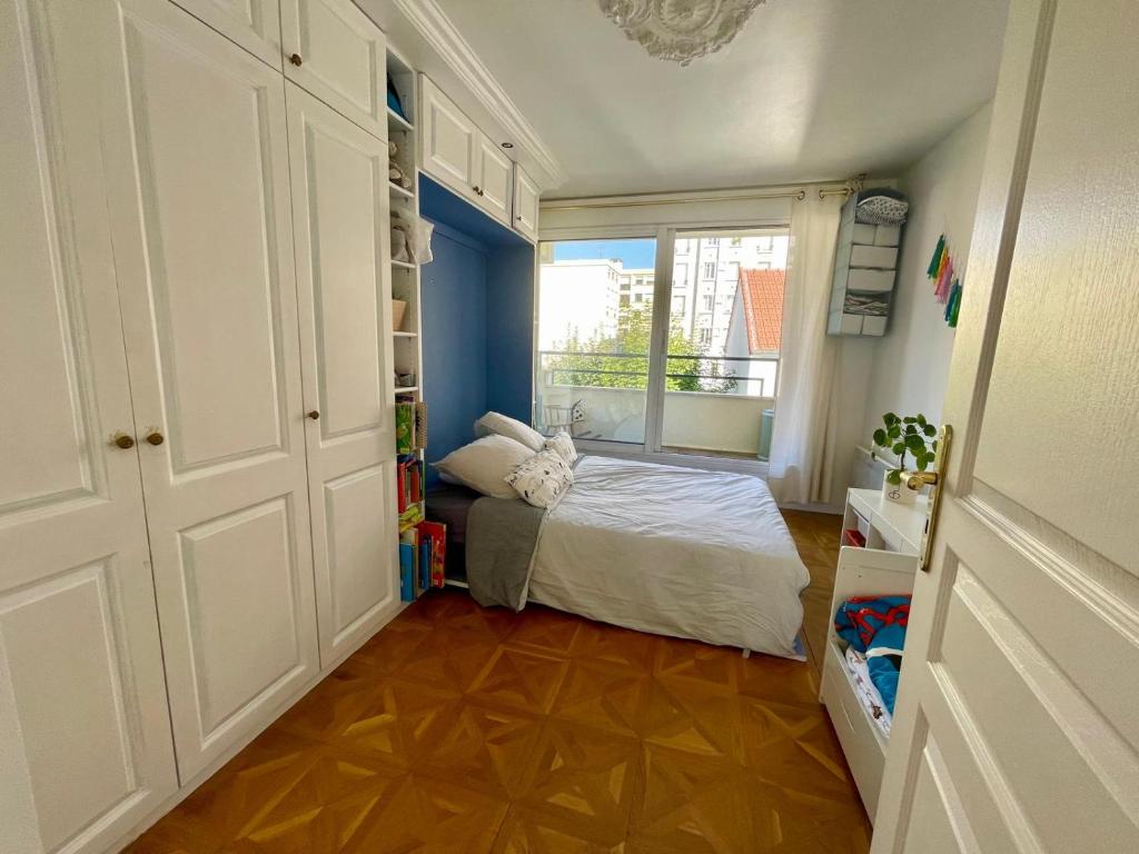 a small bedroom with a bed and a window at 2 BEDROOMS & TERRACE with BBQ COURBEVOIE PARIS in Courbevoie