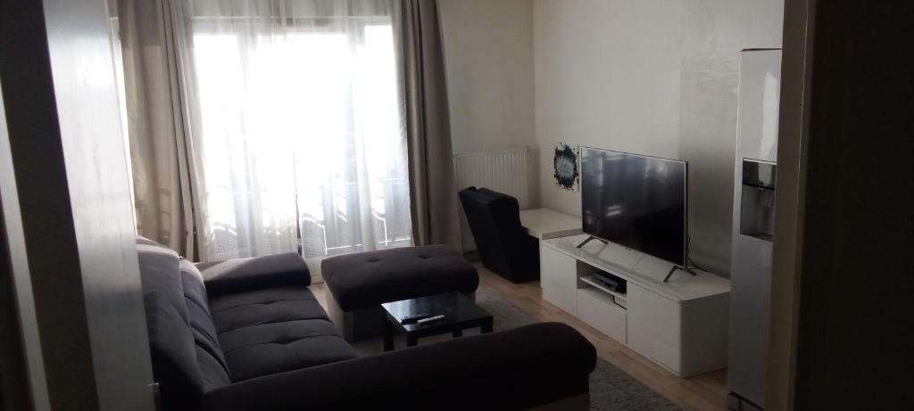 un salon avec un canapé et une télévision dans l'établissement Beautiful Appartement Gates Of Paris 5 min, à Bagnolet