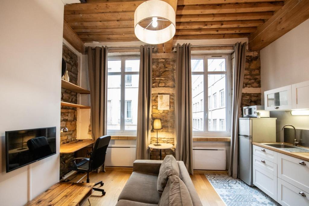 un salon avec un canapé et un bureau dans l'établissement Le petit Imbert - studio chaleureux et cozy, à Lyon