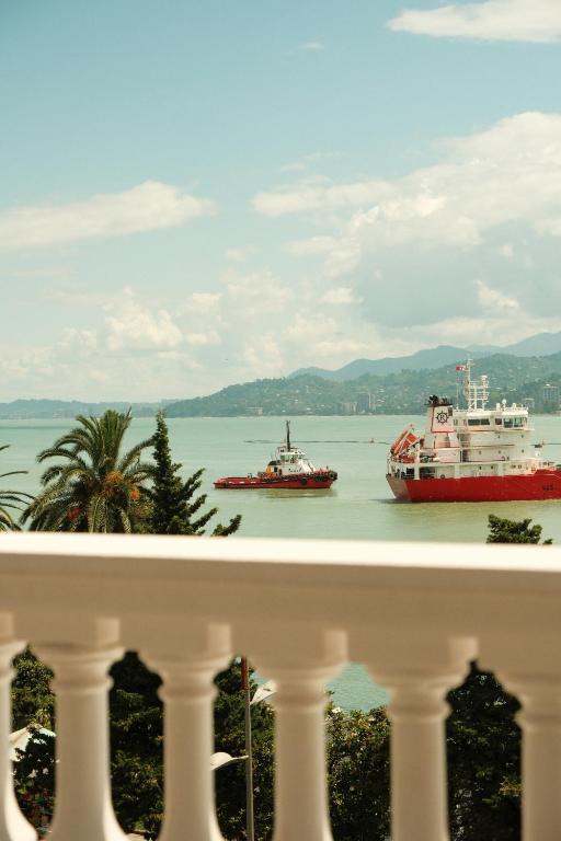 two boats floating in the water near a balcony at Le Port Boutique Apart Hotel in Batumi