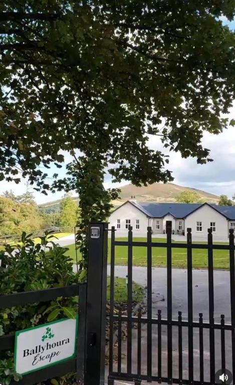 a gate in front of a white house at Ballyhoura Farm Escape Experience with Alpacas & Fairy Forest in Ballyorgan