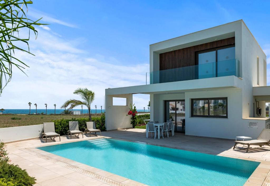una villa con piscina frente a una casa en Serenity Waves Villa 22, en Lárnaca