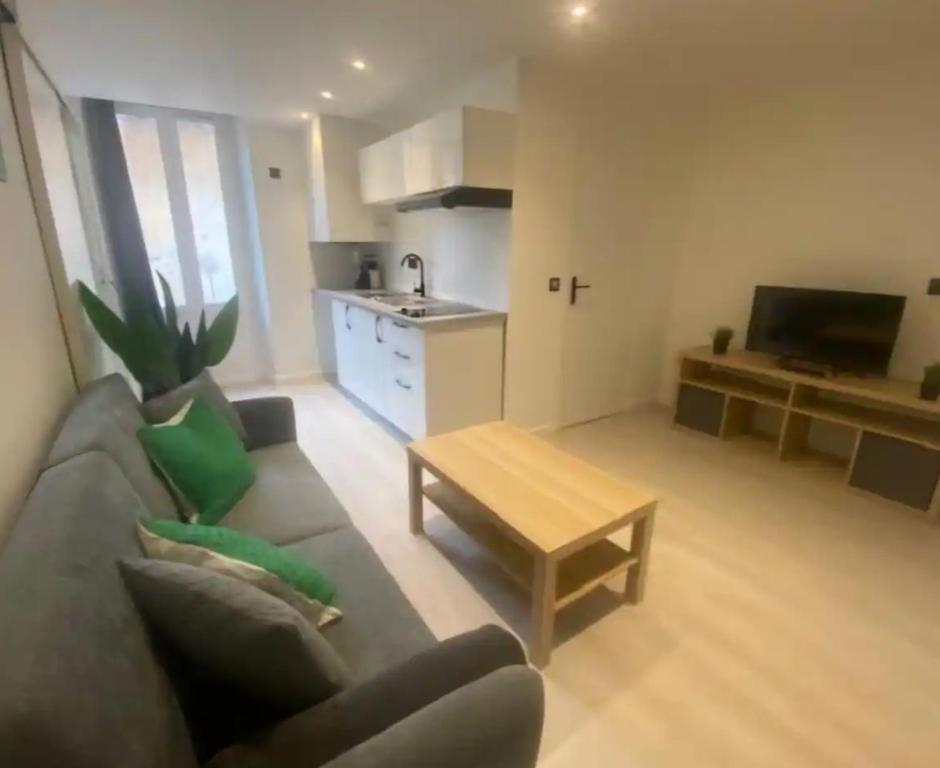 un salon avec un canapé et une table et une cuisine dans l'établissement Appartement proche de la mer, à Vallauris