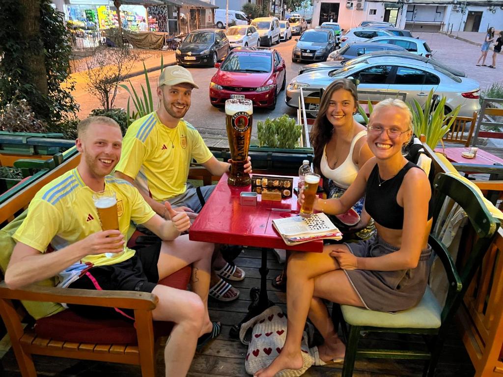 un gruppo di persone sedute a un tavolo a bere birra di Hostel Chilli a Tirana