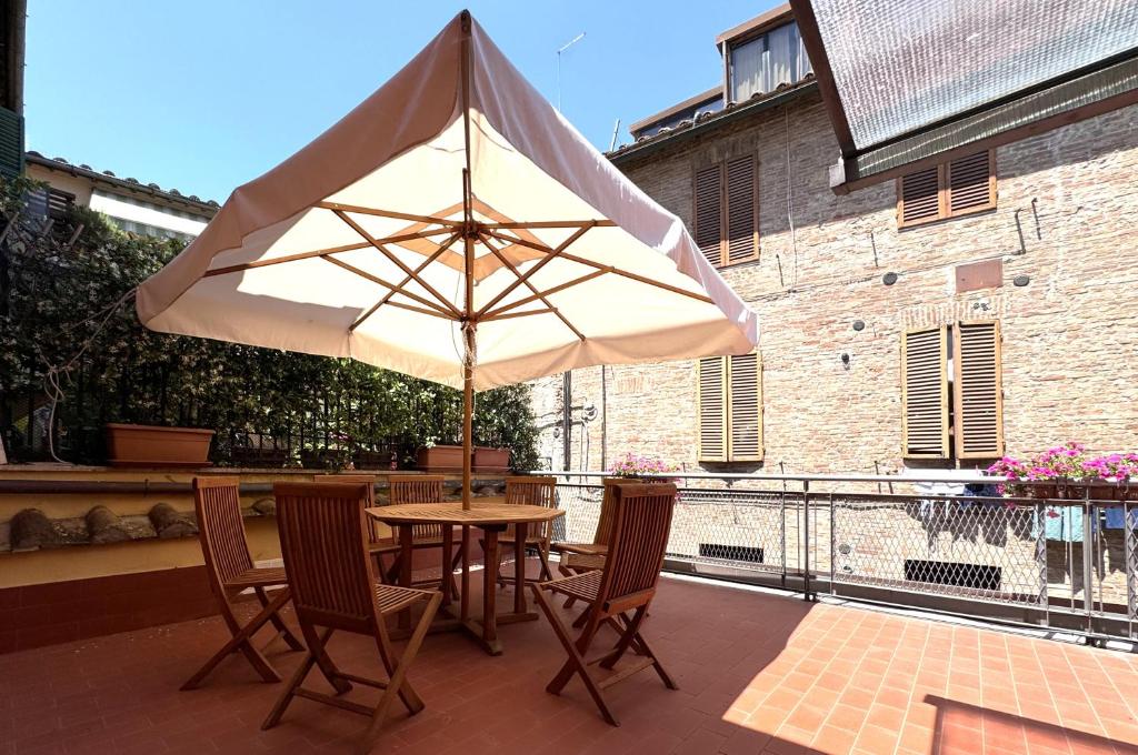 a table and chairs with an umbrella on a patio at Le terrazze di Camollia in Siena
