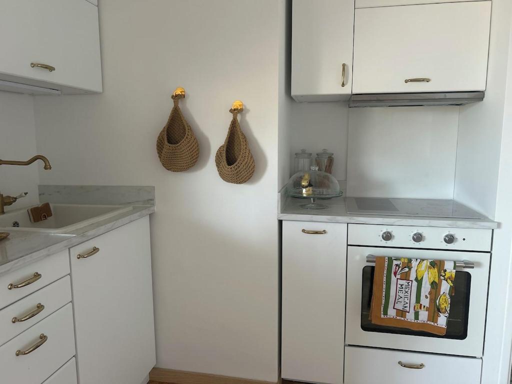 La cuisine est équipée de placards blancs et d'un four avec plaques de cuisson blanches. dans l'établissement T2 ville et bord de mer, à Ajaccio