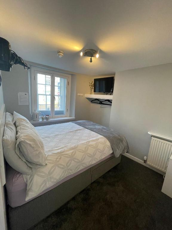 a bedroom with a large bed in a room at Black Bull with Rooms lower in Cumbernauld