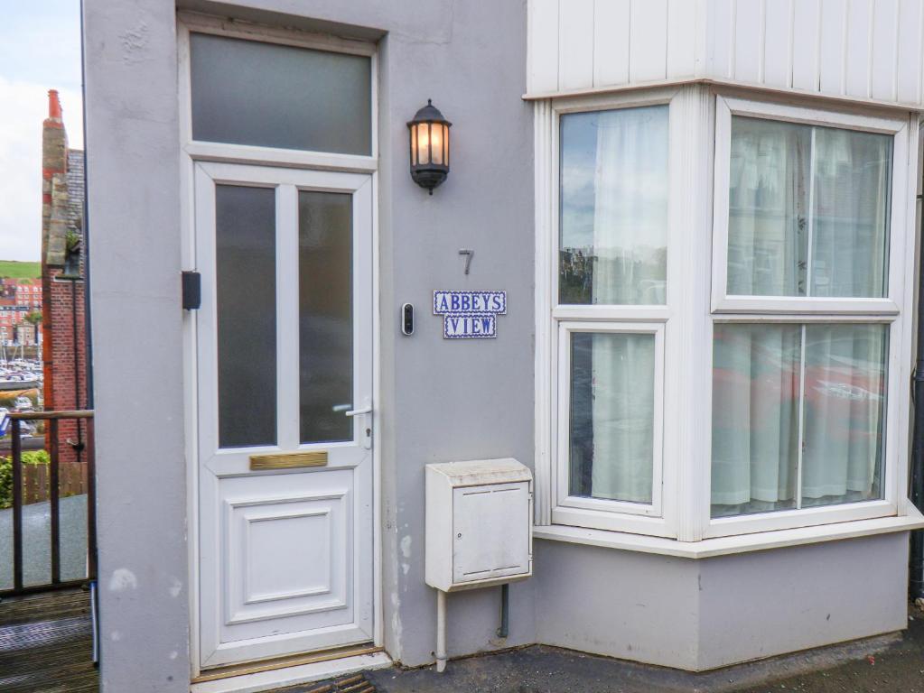 a white door of a building with a sign on it at Abbey's View in Whitby