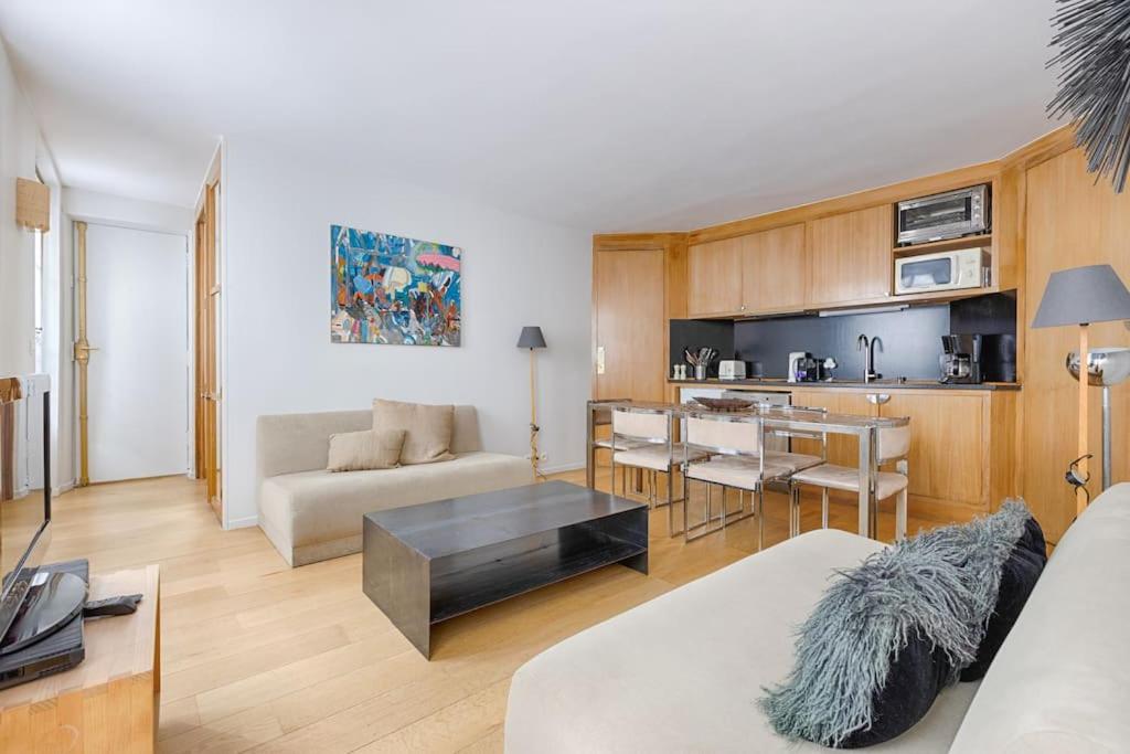 un salon avec un canapé et une table dans l'établissement Luxury Apartment Saint Honore Champs Elysees, à Paris