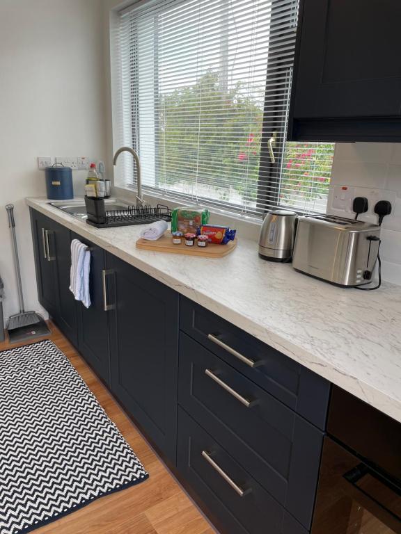 a kitchen with black cabinets and a counter top at Marta Studio Apartment in Ennistymon