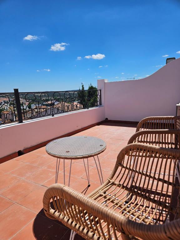 a patio with a table and chairs on a balcony at Solar de Arrayollos by PURUS in Arraiolos