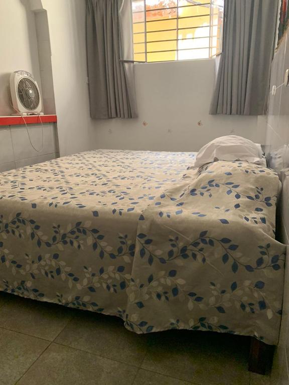 a bedroom with a bed with a blue and white comforter at Hospedaje Hamuys Lodge in Ica