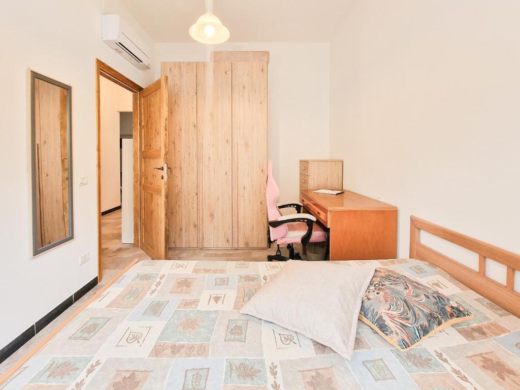 Un dormitorio con una cama, un escritorio y una silla. en Casa La Torre Rio Marina, en Rio Marina