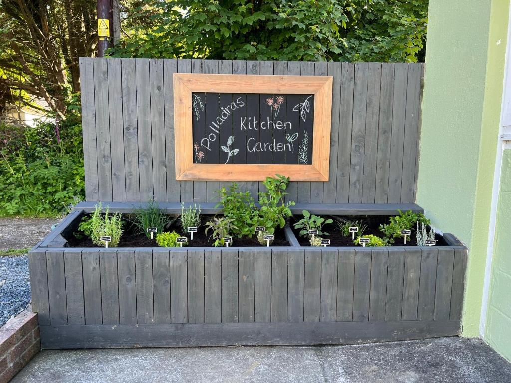 a raised garden with plants in a wooden fence at Polladras Holiday Park in Helston