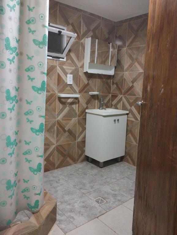 a bathroom with a sink and a shower curtain at El Campanario in Malargüe